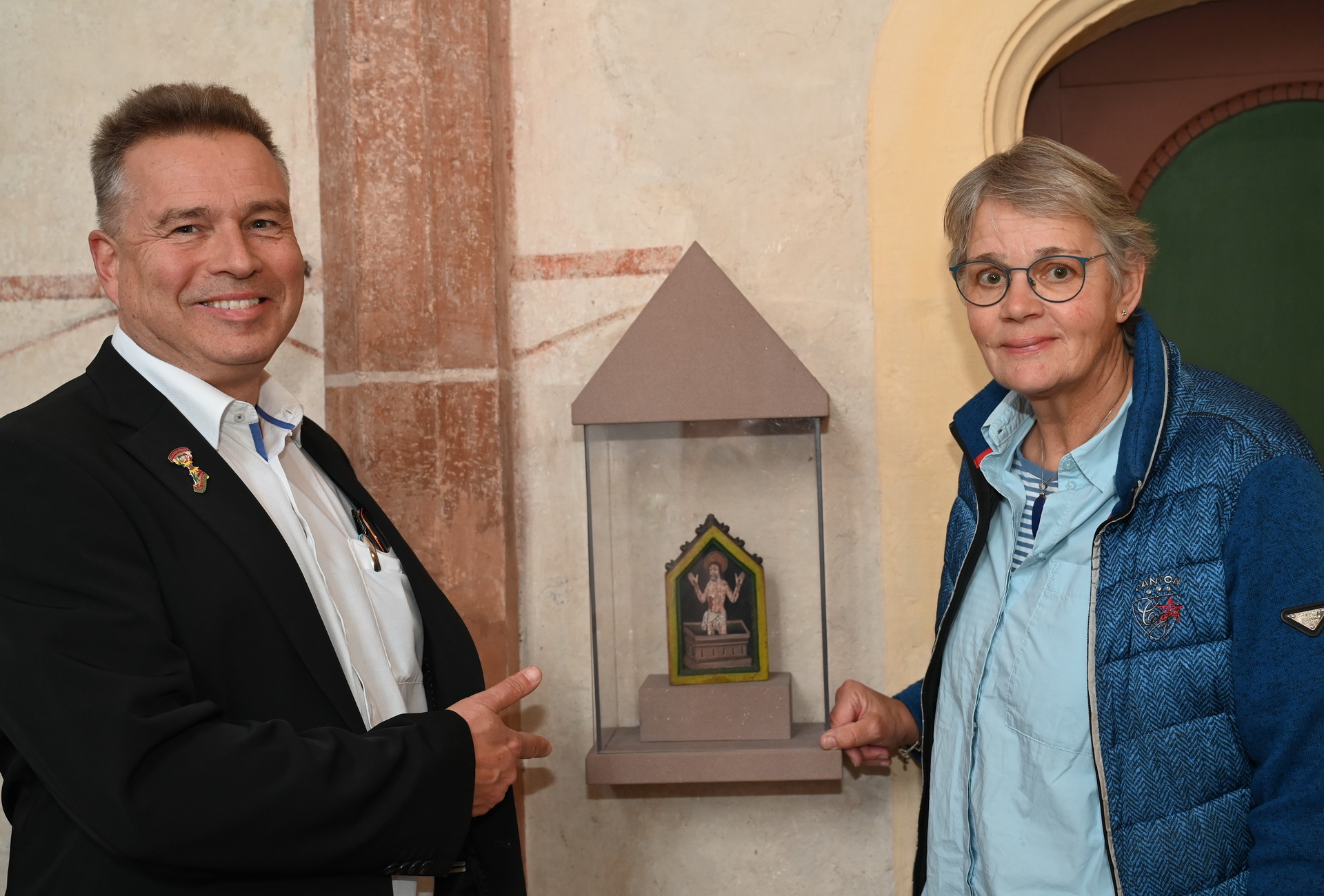 Claudia Müller und Peter Schweikert-Wehner am Hosteler Pax-Täfelchen. Es handelt sich bei diesen früher gebräuchlichen liturgischen Gegenständen um mit Darstellungen Christi, Mariens oder Heiliger verzierte Täfelchen, die zur Weitergabe des Friedenskusses in der Messe dienten. Foto: Manfred Lang/pp/Agentur ProfiPress