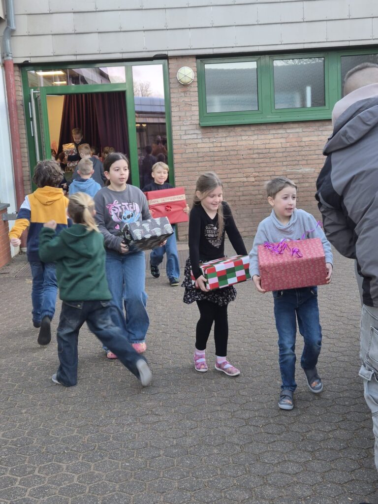 Hand in Hand für den guten Zweck: Per Menschenkette wanderten die Päckchen der Katholischen Grundschule Lückerath in den Wagen der Tafel. Foto: Kerstin Rottland/pp/Agentur ProfiPress