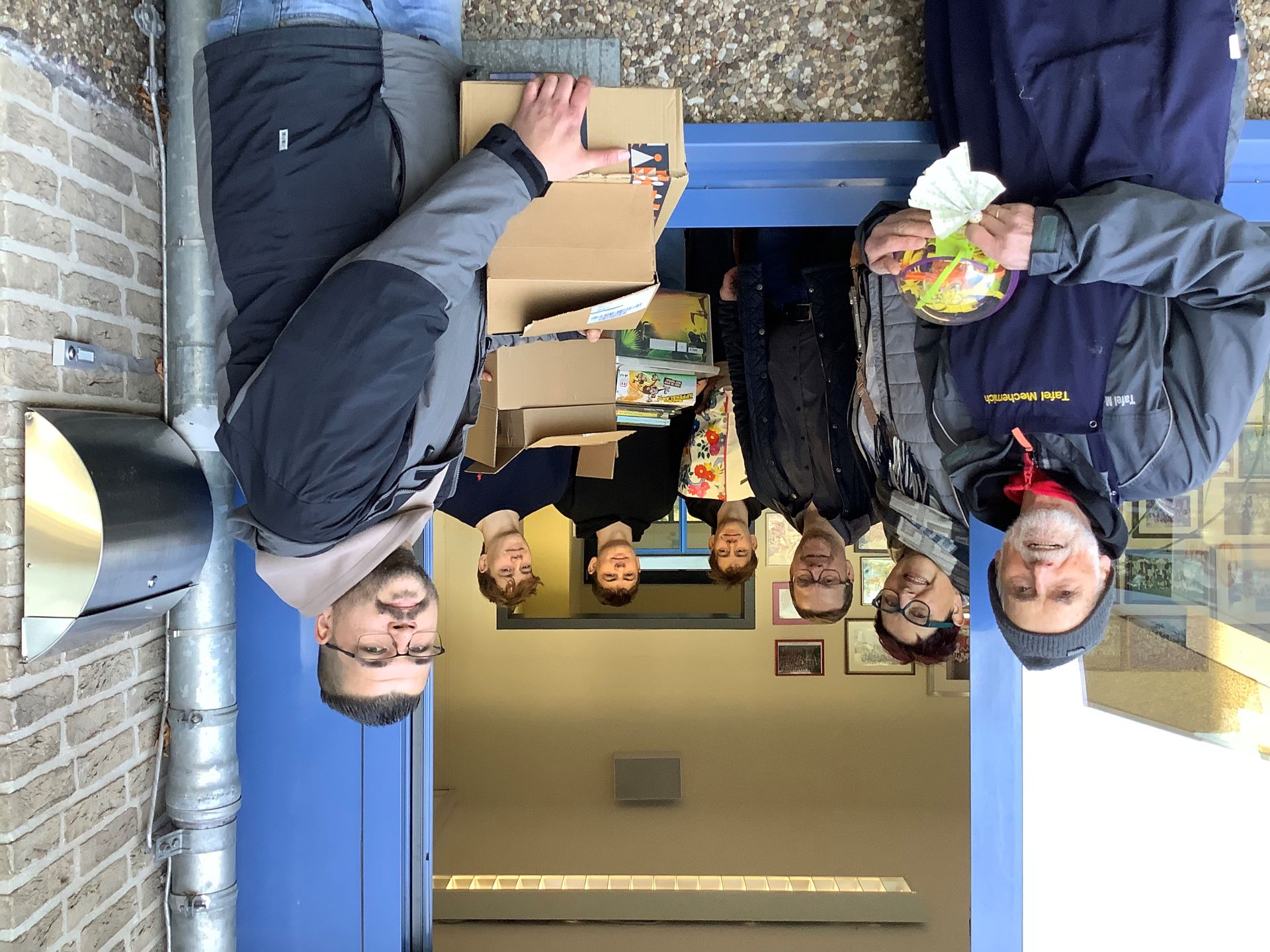Kurze Wege: Aus dem Fenster gereicht wurden die gut bestückten Pakete, die die Schülerschaft des Gymnasium am Turmhof unter Direktor Micha Kreitz (3. V. l.) für die Weihnachtsaktion der Tafel gesammelt hatte. Foto: GAT/pp/Agentur ProfiPress