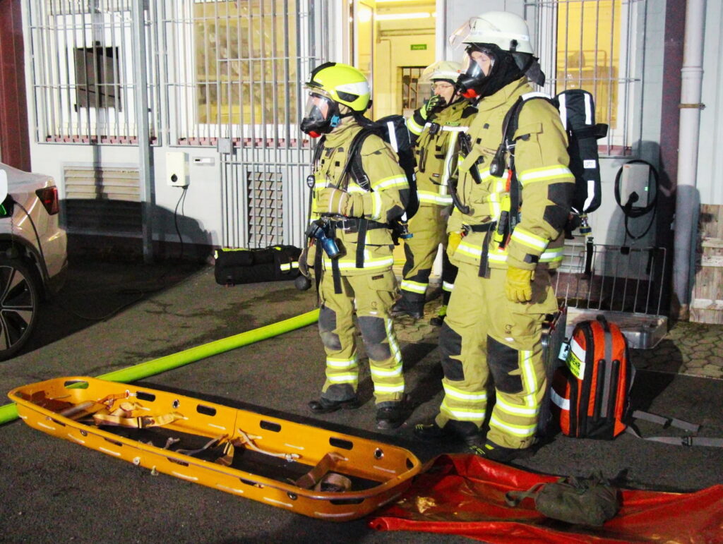 Feuerwehrmänner unter schwerem Atemschutz nach der so genannten „Crashrettung“ eines eingeschlossenen Arbeiters in der brennenden Werkshalle. Foto: David Langstein/FF Mechernich/pp/Agentur ProfiPress