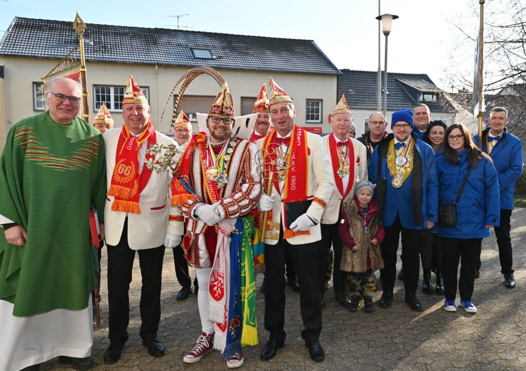 Prinz Torsten I. trägt die Schals aller drei Zentral-Mechernicher Karnevalsgesellschaften am Gürtel, während sich Fahnenabordnungen des Festausschusses und der Prinzengarde zum gemeinsamen Einzug mit Pfarrer und Sitzungspräsident Erik Pühringer startklar für den Einzug ins Gotteshaus machen. Foto: Manfred Lang/pp/Agentur ProfiPress