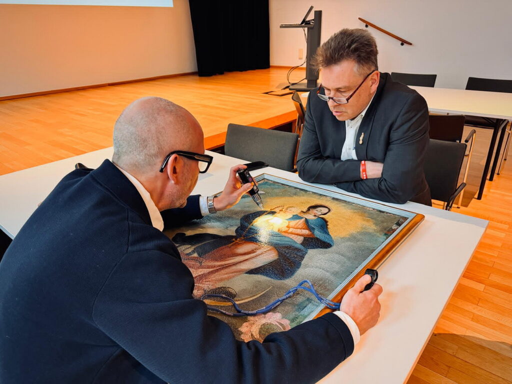 Ende Februar 2026 stellt der Mechernicher Kirchenkunstexperte Dr. Peter Schweikert-Wehner (r.) das Rosenkranzmadonnen-Gemälde im Museum für Angewandte Kunst Köln (MAKK) dem Kunstsachverständigen Christoph Bouillon vor. Foto: Privat/pp/Agentur ProfiPress