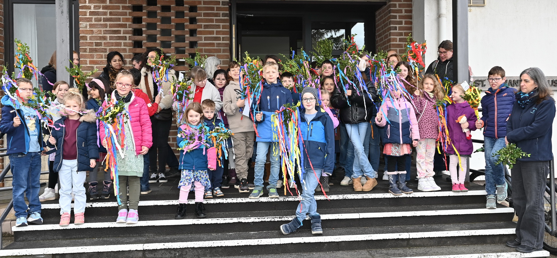 Zeigt her Eure Stöcke: Zahlreiche Familien, Kinder und Gemeindemitglieder versammelten sich zunächst am Johanneshaus, wo der Familienmesskreis Kinder schon weit vor Gottesdienstbeginn zum Basteln von Palmstöcken eingeladen hatte. Foto: Manfred Lang/pp/Agentur ProfiPress
