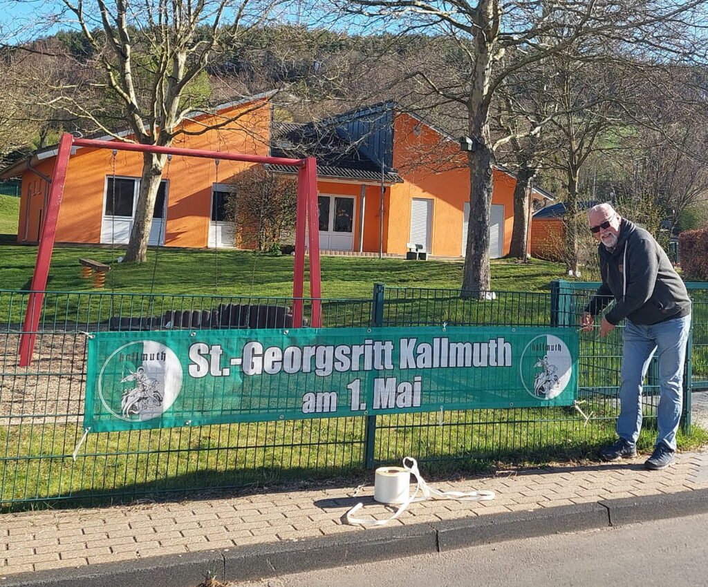 Auch vor dem Kallmuther Awo-Kindergarten bringt Ortsbürgermeister Robert Ohlerth ein Transparent für den 72. Sankt-Georgs-Ritt an. Foto: Gerhard Mayr-Reineke/pp/Agentur ProfiPress