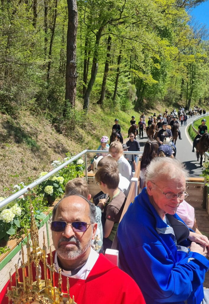 Auf dem Rückweg mit Monstranz auf dem Sakramentenwagen Father Dr. Shaji Thomas Manikulam aus Indien und Altm3essdiener Michael Loebel aus Breitenbenden, dahinter die Kommunionkinder auf der Sitzbank und die Reiter. Foto: Manfred Lang/pp/Agentur ProfiPress