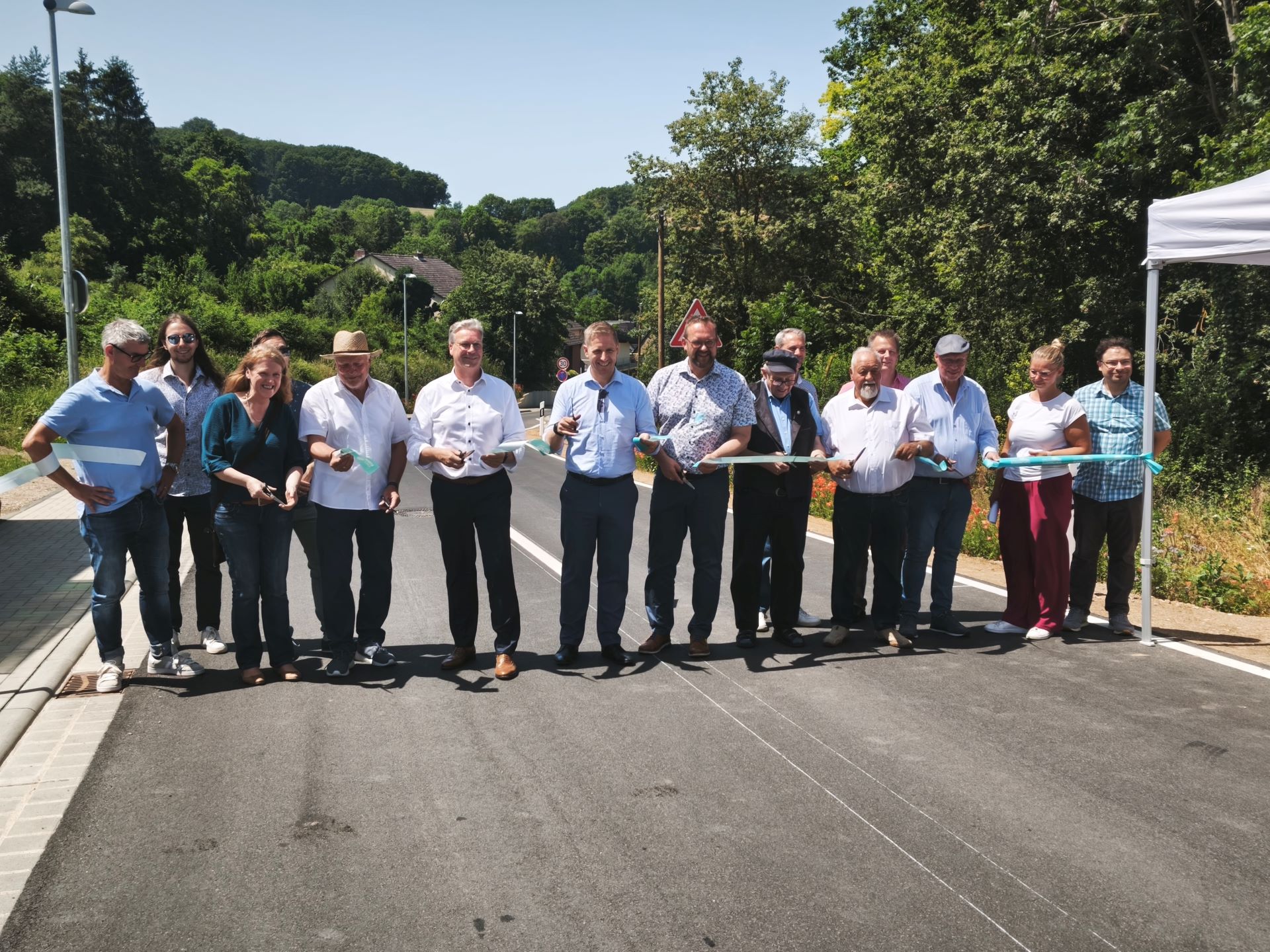 Freie Fahrt zwischen Eiserfey und Harzheim: Landrat Markus Ramers, dessen Allgemeiner Vertreter Achim Blindert, zahlreiche Mitglieder des Stadtrats, der Firma Wurzel Bau sowie gleich mehrere Ortsbürgermeisterinnen und Ortsbürgermeister. Foto: Kerstin Rottland/pp/Agentur ProfiPress