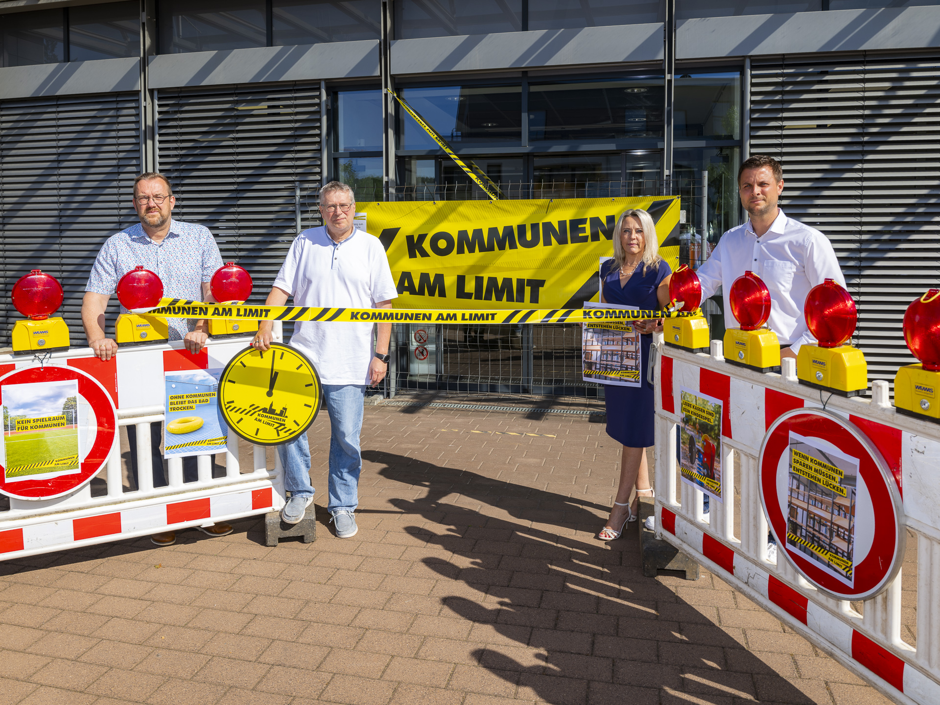 Mit Warnbaken, roten Signalleuchten und Flatterband machte die Mechernicher Verwaltung am Rathaus auf die angespannte Finanzlage der Kommunen aufmerksam, hier mit Bürgermeister Michael Fingel (v.r.), seiner Persönlichen Referentin Manuela Holtmeier, dem Kämmerer Stefan Mannz und dem Erste Beigeordneten Thomas Hambach. Foto: Ronald Larmann/pp/Agentur ProfiPress