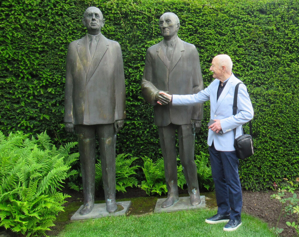 Ein symbolischer Händedruck: Künstler Tom Krey begegnete im Garten des Adenauer-Hauses in Rhöndorf den Skulpturen von Charles de Gaulle und Konrad Adenauer, passend zum europäischen Leitgedanken seines Gemäldes. Foto: Maggie Krey/pp/Agentur ProfiPress