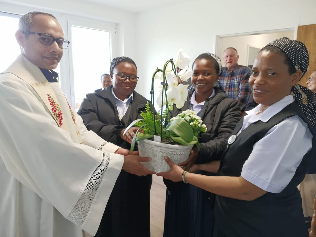 Nach der Einsegnung des Wohnbereiches der Heilig-Geist-Schwestern im Centro Communio überreichte ihnen Generalsuperior Pfarrer Jaison Thazhathil eine Orchidee für ihr neues Zuhause: (v. r.) Oberin Schwester Paskaria, Schwester Maria Paul und Schwester Devotha. Foto: CIC/pp/Agentur ProfiPress