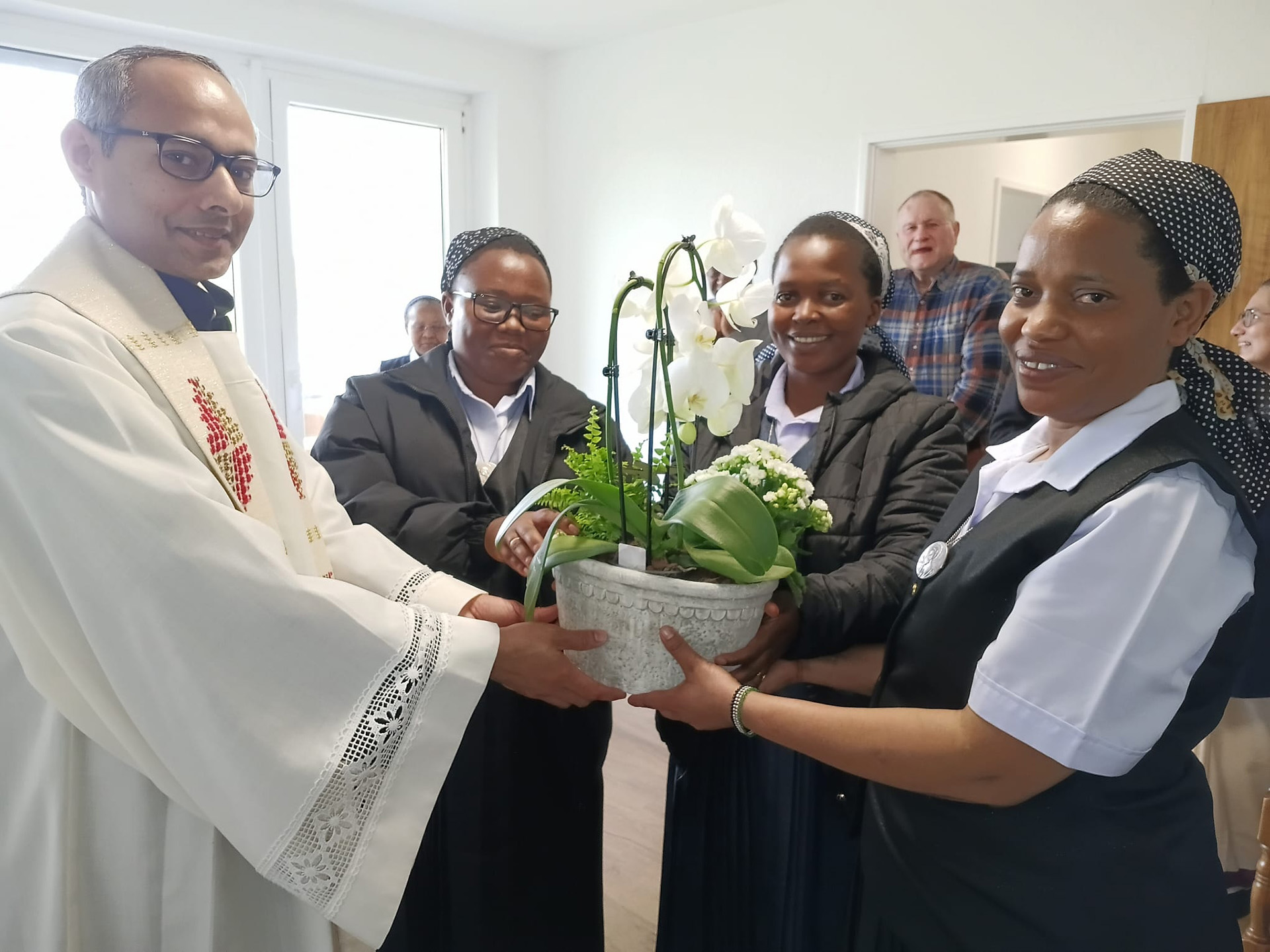 Nach der Einsegnung des Wohnbereiches der Heilig-Geist-Schwestern im Centro Communio überreichte ihnen Generalsuperior Pfarrer Jaison Thazhathil eine Orchidee für ihr neues Zuhause: (v. r.) Oberin Schwester Paskaria, Schwester Maria Paul und Schwester Devotha. Foto: CIC/pp/Agentur ProfiPress