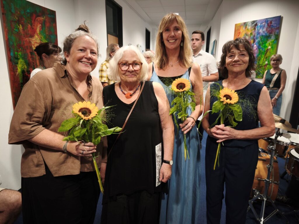Als Dankeschön überreichte Donata Reinhard (2.v. l,) jeweils eine Sonnenblume an die für Kultur zuständige Mitarbeiterin der Stadt Mechernich Gabi Schumacher, an Kuratorin Ela Rübenach und an ihre Tochter Shirin Reinhard (von rechts). Foto: Kerstin Rottland/pp/Agentur ProfiPress
