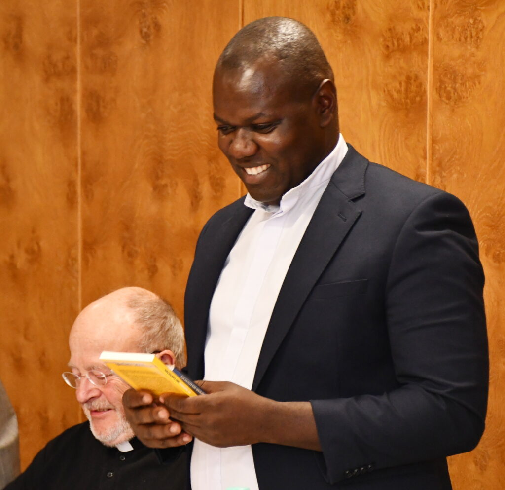 Freude und Wehmut lagen bei der Verabschiedung dicht beieinander: Father Patrick Mwanguhya reagierte sichtlich bewegt und zugleich heiter auf die vielen persönlichen Dankesworte. Links an seiner Seite, der „weiße Bruder“ Diakon Manni Lang. Foto: Sabine Roggendorf/pp/Agentur ProfiPress