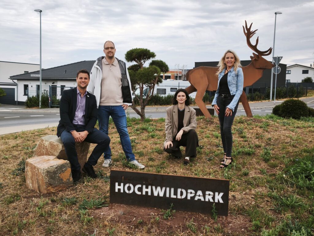 Blickfang und Wegweiser: Bürgermeister Michael Fingel (v.l.), Christian Kaschub vom städtischen Team Straßen/Grünflächen, Hochwildpark-Chefin Pia Jensch sowie Bürgermeister-Referentin Manuela Holtmeier trafen sich am neu gestalteten Kreisel bei Kommern-Süd. Foto: Kerstin Rottland/pp/Agentur ProfiPress