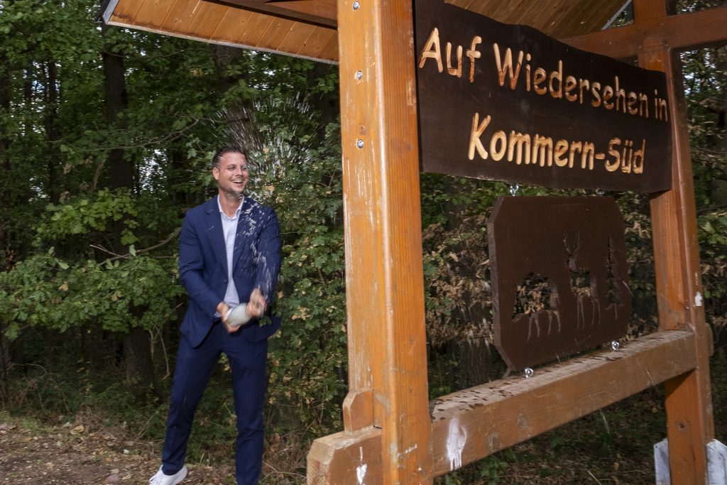 Mit einer ordentlichen Sektdusche taufte Bürgermeister Michael Fingel den neuen Blickfang von Kommern-Süd. Das beidseitige Schild begrüßt Gäste und verabschiedet sie Richtung Katzvey. Foto: Ronald Larmann/pp/Agentur ProfiPress