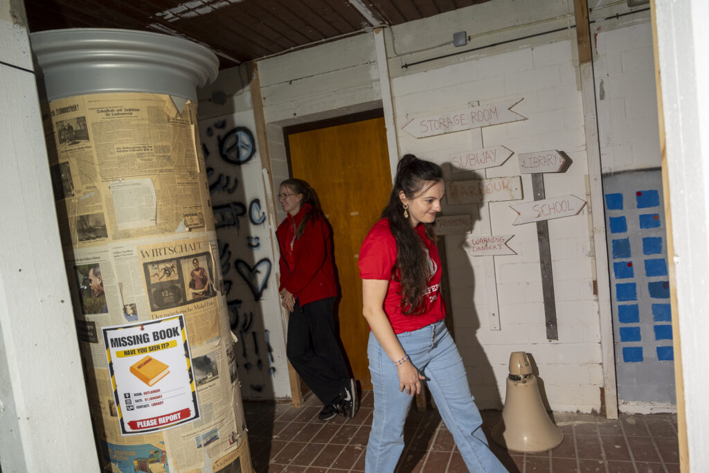 Schule, Hafen, Krankenhaus oder Lagerraum: Wegweiser führten durch das von den Camp-Teilnehmern entwickelte Kriegsszenario im Rotkreuz-Fluchthaus. Foto: Ronald Larmann/pp/Agentur ProfiPress