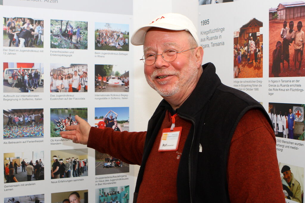 Geschichte lebendig machen und jungen Menschen die Werte des Roten Kreuzes vermitteln: Rolf Zimmermann vor einer Schautafel, die von internationalen Hilfseinsätzen, Jugendrotkreuz und Begegnungen über Ländergrenzen hinweg erzählt. „Er hatte die sieben Grundsätze des Roten Kreuzes verinnerlicht und zu seinem Lebenskompass erklärt: Menschlichkeit, Unparteilichkeit, Neutralität, Unabhängigkeit, Freiwilligkeit, Einheit und Universalität“, so DRK-Kreisvorsitzender Karl-Werner Zimmermann. Foto: Privat/pp/Agentur ProfiPressProfiPress