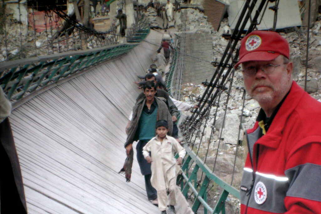 Humanitäre Hilfe war für Rolf Zimmermann kein abstrakter Begriff: Nach dem verheerenden Erdbeben von 2005 war der Rotkreuzmann selbst in Pakistan im Einsatz. Das Foto zeigt den begnadeten Logistiker und Organisator an einer schwer beschädigten Behelfsbrücke inmitten der Zerstörungen. Foto: Privat/pp/Agentur ProfiPress