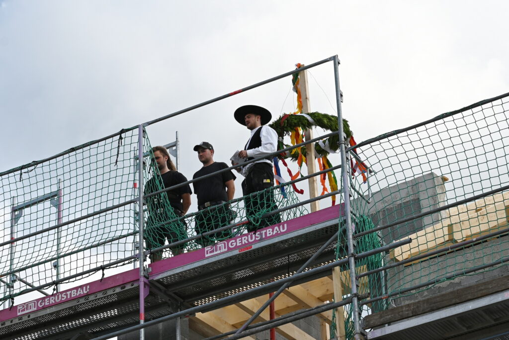 Hoch oben am Richtkranz: Ansgar Ulrich, Tom Breitzter und Zimmerermeister Tim Kessel (v.l.). Kessel sprach den traditionellen Richtspruch und wünschte: „Gesegnet dieses Haus und alle, die gehen ein und aus.“ Foto: Manfred Lang/pp/Agentur ProfiPress