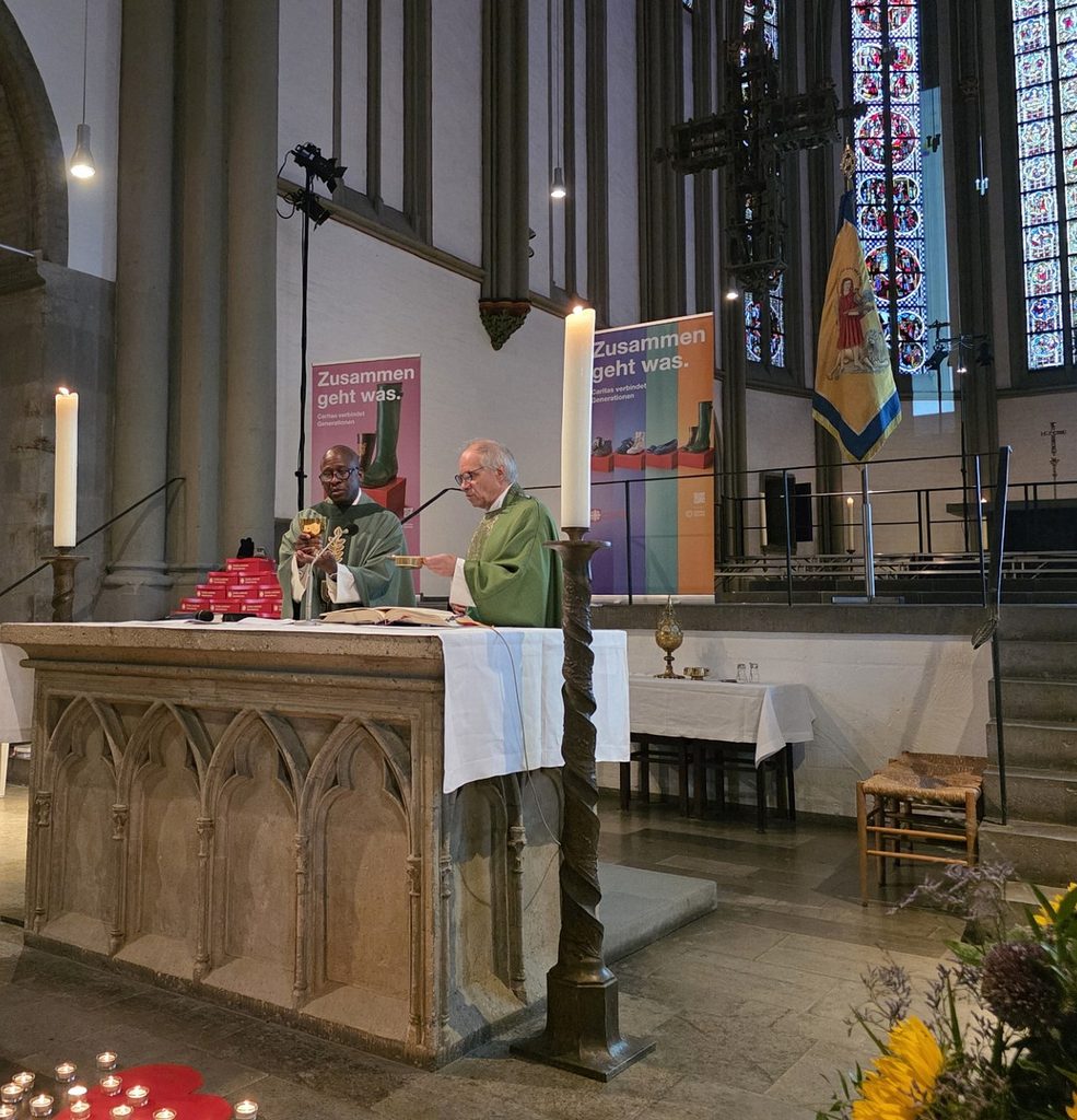 Pater Jean Elex Normil CS (l.) und Propst Dr. Peter Blättler bei der Doxologie am Ende des Eucharistischen Hochgebets im Vitusmünster: „Durch ihn und mit ihm und in ihm…“ Der Gottesdienst wurde unter dem Motto „Zusammen geht was“ vom Caritasverband Region Mönchengladbach und zahlreichen ehrenamtlich engagierten Frauen mitgestaltet. Foto: Manfred Lang/pp/Agentur ProfiPress