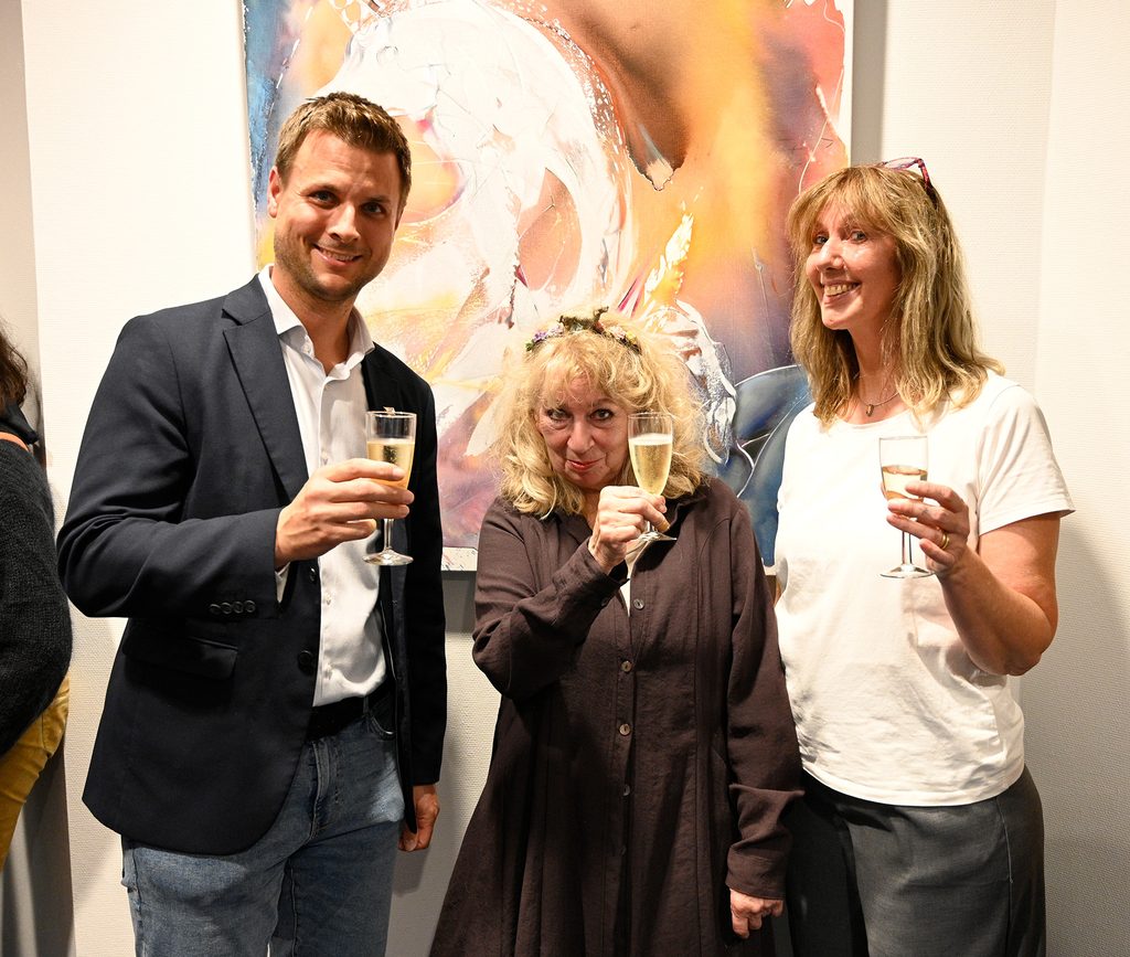Cheers! Auf die erfolgreiche Vernissage ihrer außergewöhnlichen Ausstellung „A painting a day keeps the doctor away“ in der Mechernicher Galerie im Rathaus stieß Künstlerin Maf Räderscheidt mit Kuratorin Ela Rübenach (r.) und Bürgermeister Michael Fingel an. Foto: Henri Grüger/pp/Agentur ProfiPress