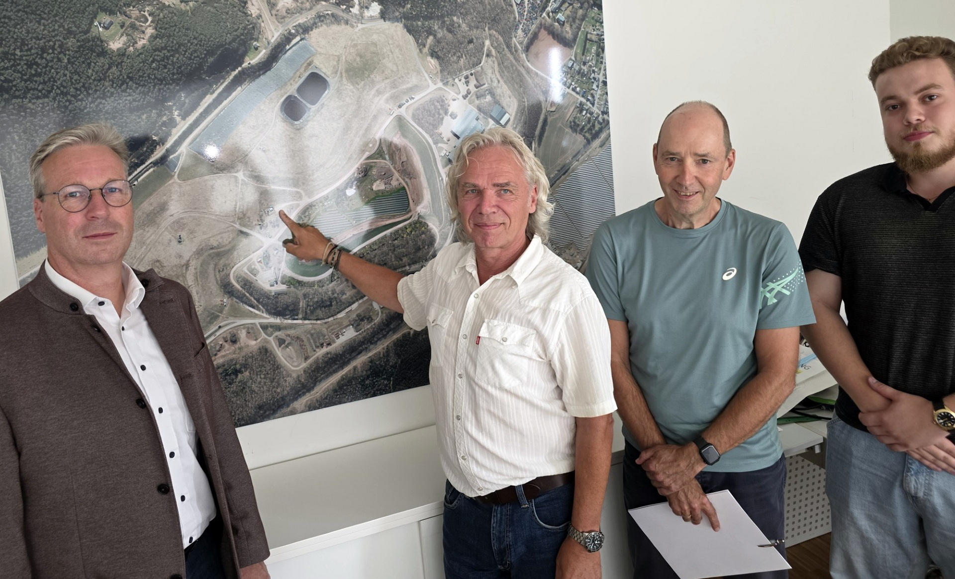 Gruppenbild vor Deponieluftbild Achim Blindert, allgemeiner Vertreter des Landrats, Deponieleiter Michael Weber, Kreispressereferent Wolfgang Andres und sein Mitarbeiter Tristan Eggert (v.l.) erläuterten vor einem Luftbild des Abfallwirtschaftszentrums Mechernich die heutige Situation am ehemaligen Tagebau Virginia. Foto: Manfred Lang/pp/Agentur ProfiPress