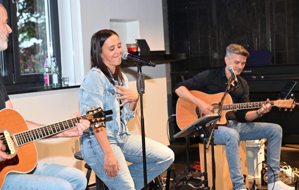 Nicole Flittorf führte mit kräftiger Stimme und viel Humor durch den Abend. David Merzenich (r.) und Gerd Becker begleiteten sie an der Gitarre und auf dem Bass. Foto: Manfred Lang/pp/Agentur ProfiPress